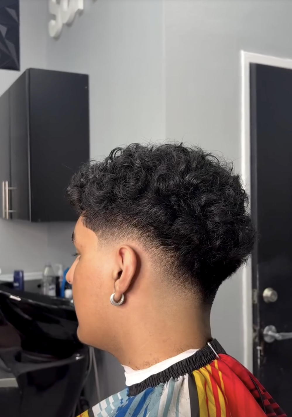 Curly taper fade haircut from the side