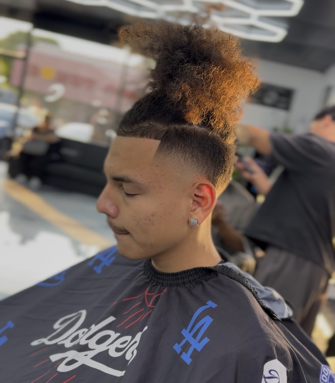 High top fade haircut in warm shop lighting